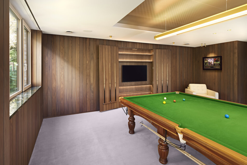 A view of the panelling in the contemporary snooker room with the cue cupboard doors open revealing the television