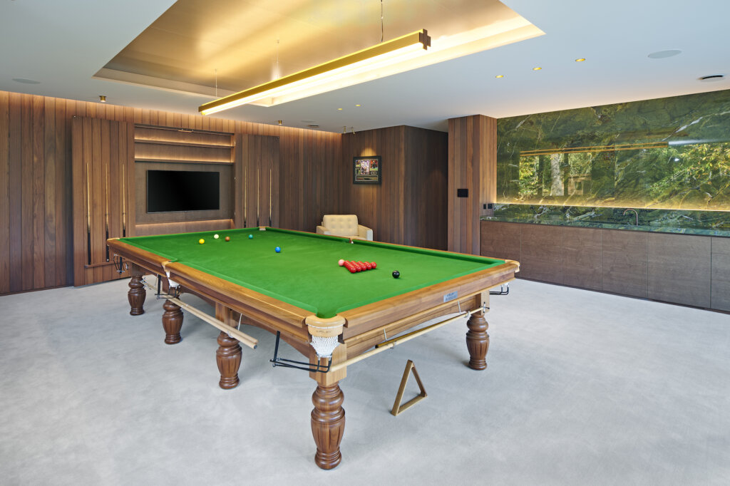 A general of view of the contemporary snooker room with the snooker table in the centre and the bar and cue cupboard behind