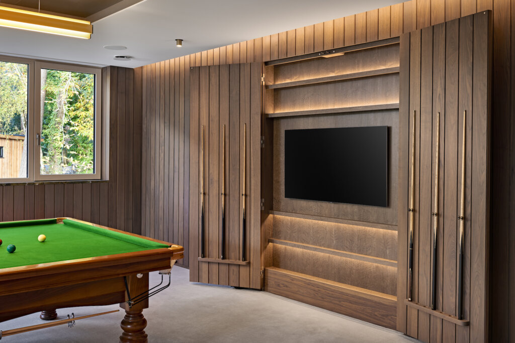 In this contemporary snooker room the cue cupboard doors open wide to reveal a flat screen television