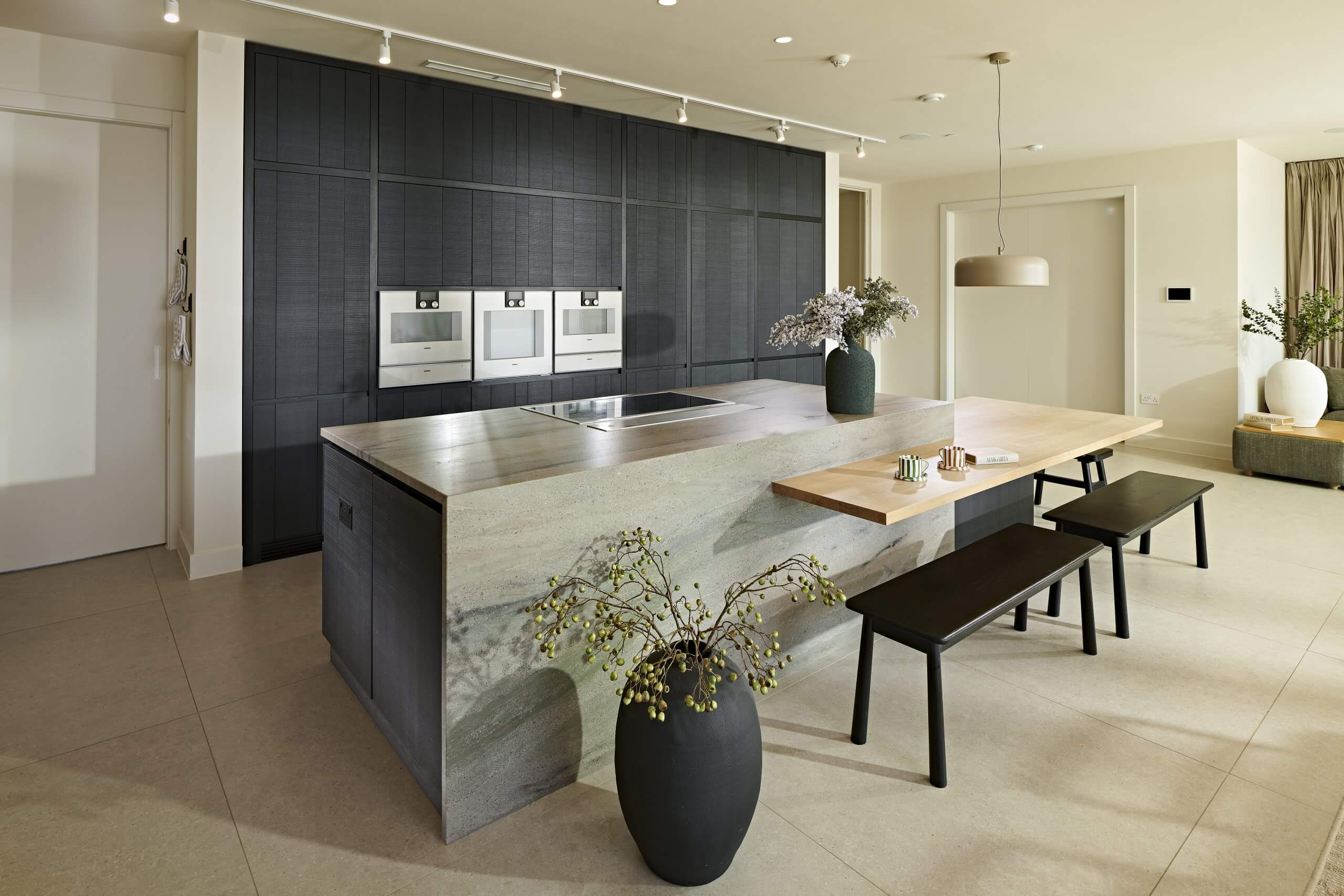 the waterfall island featuring the low breakfast bar with the appliance wall behind