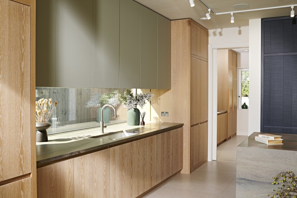 Hidden Lake kitchen sink wall with pocket doors closed and looking towards the open utility room door and a glimpse of the continuation of the cabinetry