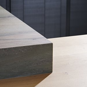detail of the Verde Lara island worktop meeting the natural oak breakfast bar top